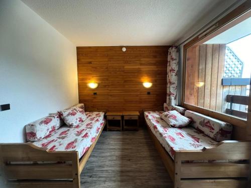 une chambre avec deux lits et une fenêtre dans l'établissement Residence 3000 Bail - Studio pour 4 Personnes 12, à Mâcot La Plagne
