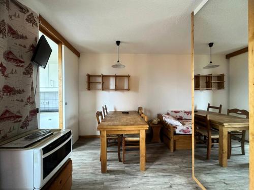 - une cuisine et une salle à manger avec une table et une cuisinière dans l'établissement Residence 3000 Bail - Studio pour 4 Personnes 12, à Mâcot La Plagne