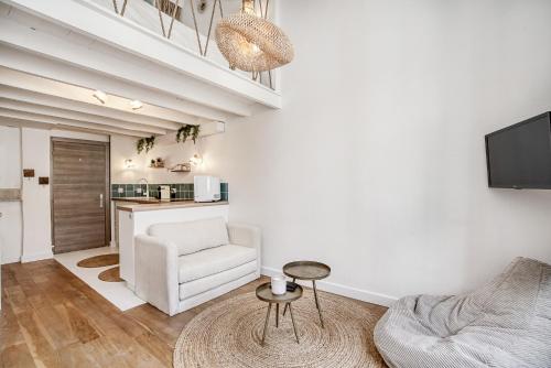 - un salon avec une chaise blanche et une table dans l'établissement My little St-Tropez, à Saint-Tropez