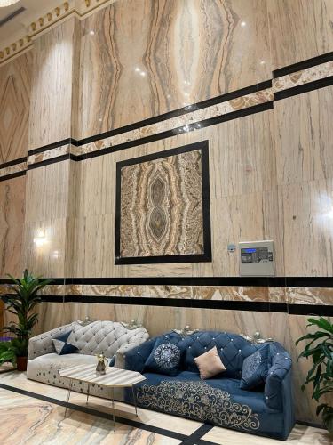 a living room with a blue couch and a table at فندق زاد المشاعر النسيم مكه in Al ‘Azīzīyah