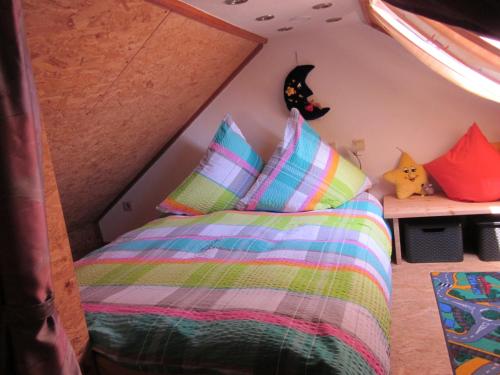 ein Schlafzimmer mit einem Bett mit bunten Kissen in der Unterkunft Eifelvulkan in Neichen