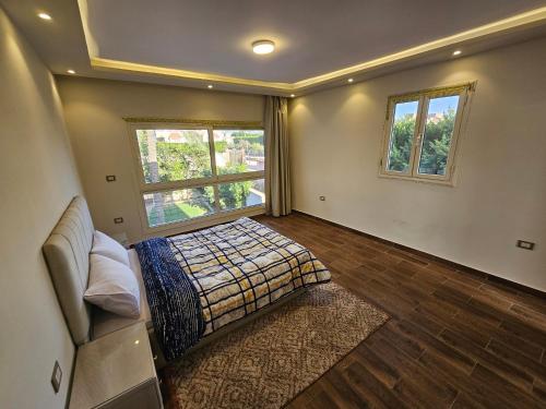 a bedroom with a bed and a couch and windows at Happy Villa For Families Only in Alexandria