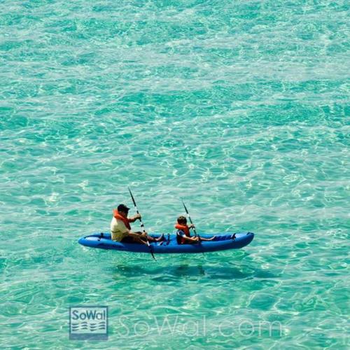 a man and a child in a blue kayak in the water at Three Pools, Steps to Beach, Dining and Shopping! in Santa Rosa Beach