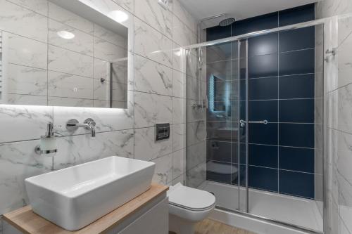 a bathroom with a sink and a shower and a toilet at Hotel w Dobieszkowie in Stryków