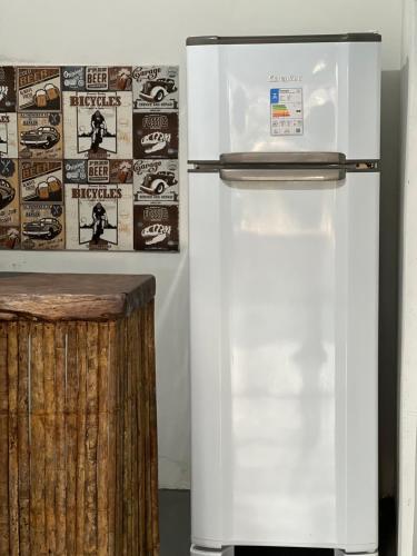 een witte koelkast in een kamer met een muur bij Vila Kairós in Caraíva