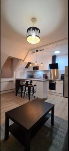 un salon avec une table et une cuisine dans l'établissement Le Doubs Montjoux, à Besançon