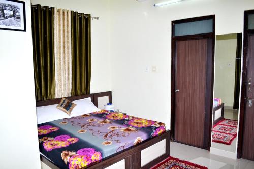 a bedroom with a bed and a door to a room at Devholiday Home in Sawāi Mādhopur