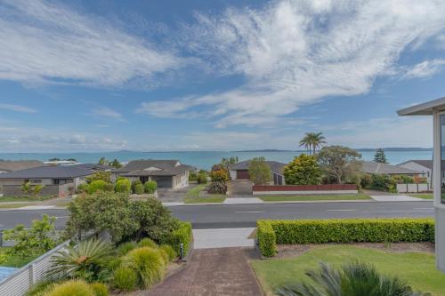an empty street in a suburb with houses at Harbour View - Maraetai Holiday Home in Auckland