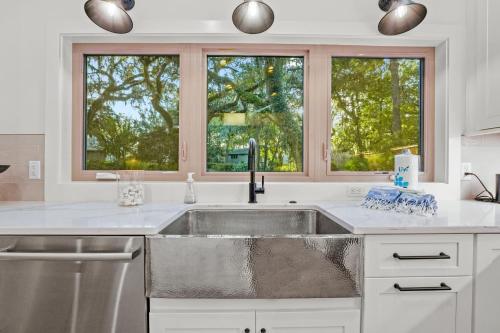 eine Küche mit Spüle und zwei Fenstern in der Unterkunft NEW LISTING - Upscale Coastal Ranch - Private Pool & Spa - 13 Planters Wood Ct in Hilton Head Island