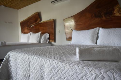 a bedroom with a large bed with white sheets and pillows at Bonding Coffee Roaster Café & Hotel in Quepos