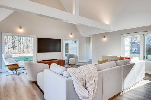 a living room with white furniture and a flat screen tv at Custom-Built Home Near Piscataqua River! in Eliot
