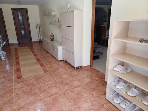 a room with white shelves and a tile floor at Casa Potcovarului in Drăguş
