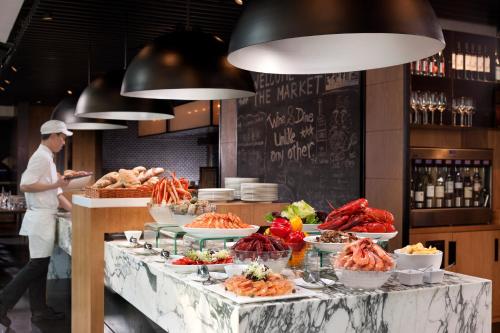 a man standing in front of a buffet of food at Hotel ICON in Hong Kong