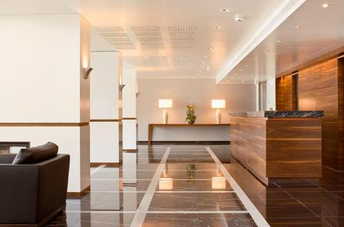 a lobby with a chair and a reception desk at Hotel Stadt Freiburg in Freiburg im Breisgau