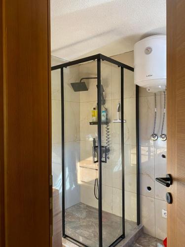 a shower with glass doors in a bathroom at Vikendica ANA in Šipovo