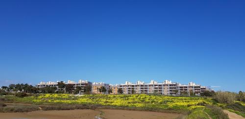 a large apartment building on a hill next to a beach at Village Marina in Olhão