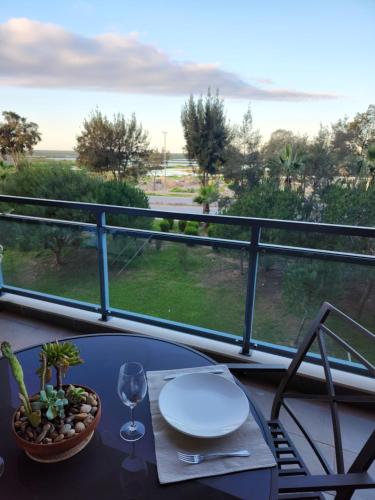 a table with a wine glass on a balcony with a view at Village Marina in Olhão