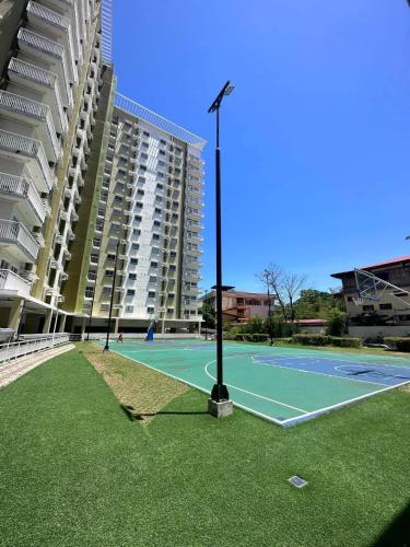 a tennis court in front of a large building at Zach's Crib at Mesaverte in Pontud