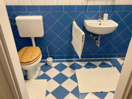 a blue tiled bathroom with a toilet and a sink at Villa Negra Vendégház in Parádsasvár