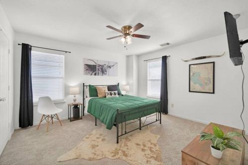 a bedroom with a green bed and a ceiling fan at Spacious Modern Retreat and Spa in Tomball