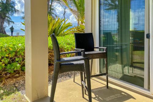 a pair of chairs with a laptop sitting on them on a porch at Islander on the Beach 164 in Kapaa