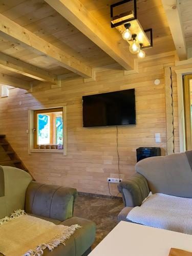 a living room with couches and a flat screen tv at Vikendica ANA in Šipovo