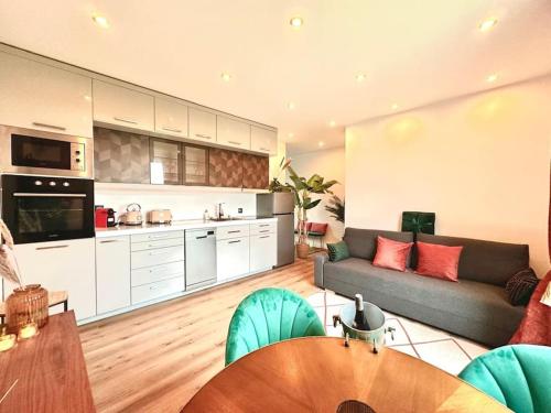 Il comprend un grand salon avec un canapé et une cuisine. dans l'établissement Suite Love & Relax, à Esbly