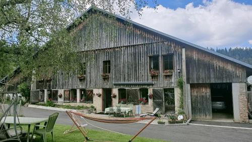a large wooden building with a boat in front of it at La Grand'Raie Table d'hôtes in Les Gras
