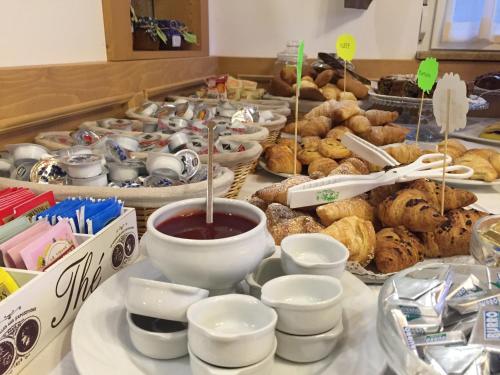 a table filled with lots of different types of pastries at Residence Hotel Miralago in Pergine Valsugana