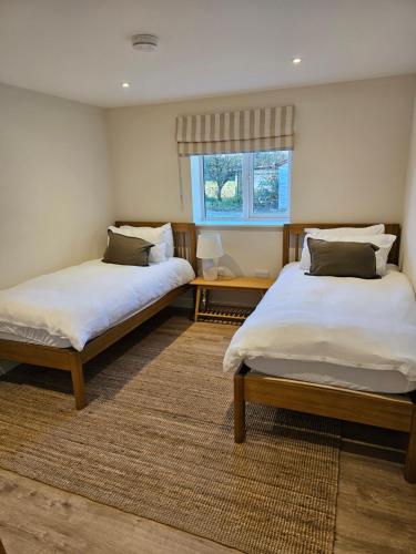 a bedroom with two beds and a window at Newditch Farm - BRS Airport in Bristol