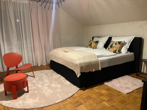 Un dormitorio con una cama y una silla roja. en Familiennest Blaustein, en Blaustein