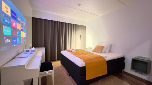 a hotel room with a bed and a desk and a tv at City Luppo - Spacious, Smart, Warm, Sauna, Wi-Fi in Rovaniemi