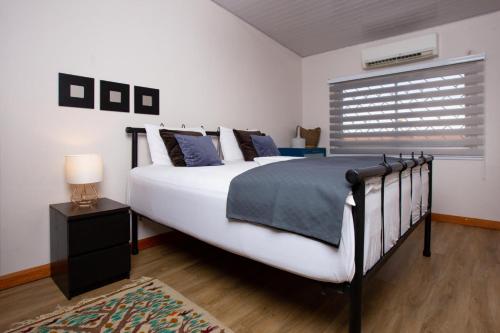 a bedroom with a large white bed and a window at Oheneba Tema - Luxury Hot -Tub Retreat with Wi-Fi in Tema