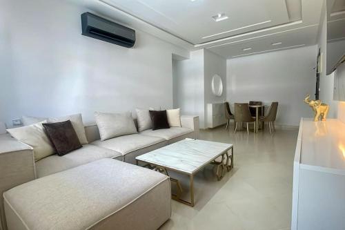 a living room with a couch and a table at The Peaceful Pavilion - 3 BR & Balcony Views in Tangier