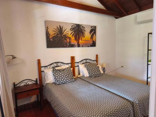 Un dormitorio con dos camas y un cuadro en la pared. en La Finca De Victoria Alojera, en Vallehermoso