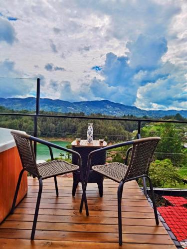 a table and two chairs on a deck with a view at La Finca De Frida in Guatapé