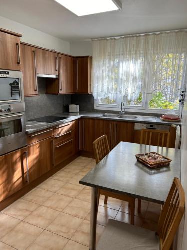 une cuisine avec des armoires en bois et une table avec des chaises dans l'établissement Appartement près de Paris et Disneyland, à Boissy-Saint-Léger