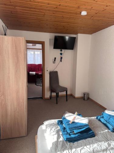 a bedroom with a bed and a chair and a mirror at Familie Zimmer in Ramsen