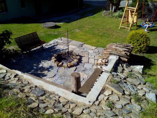 a stone fire pit in a yard with a bench at Chalupa Hořice na Šumavě in Hořice na Šumavě