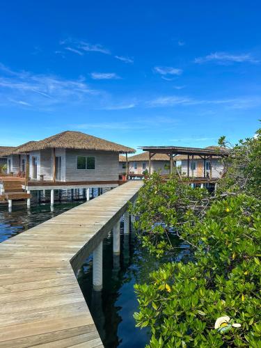 a boardwalk leading to a house on the water at CoralBay Bungalows Solarte in Solarte
