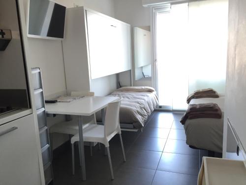 a room with a desk and a bed and a table and chairs at Residence La Nave in Senigallia