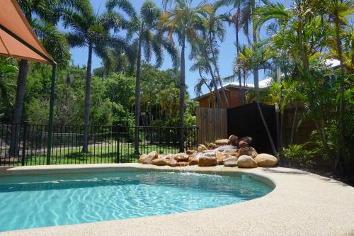 a small swimming pool in a yard with palm trees at Yongala Lodge by The Strand in Townsville