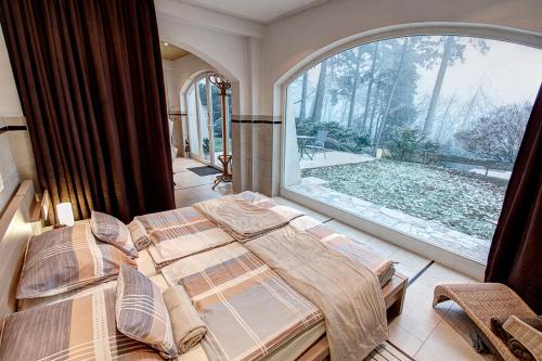 a bedroom with two beds and a large window at Private Wellness Apartment in Pécs