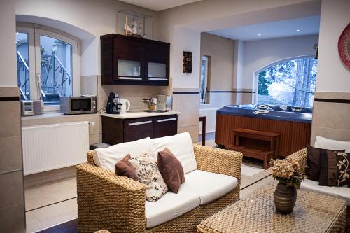 a living room with a couch and a kitchen at Private Wellness Apartment in Pécs