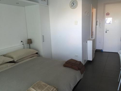 a bedroom with a bed and a clock on the wall at Residence La Nave in Senigallia