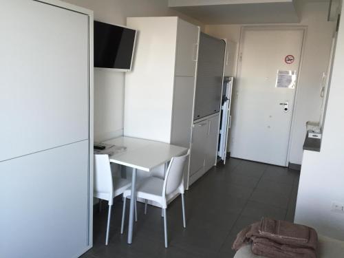 a kitchen with a table and chairs in a room at Residence La Nave in Senigallia