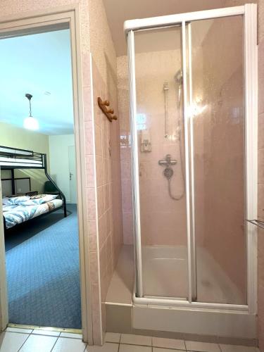 eine ebenerdige Dusche in einem Zimmer mit einem Schlafzimmer in der Unterkunft Cap'tain Cook in Caurel