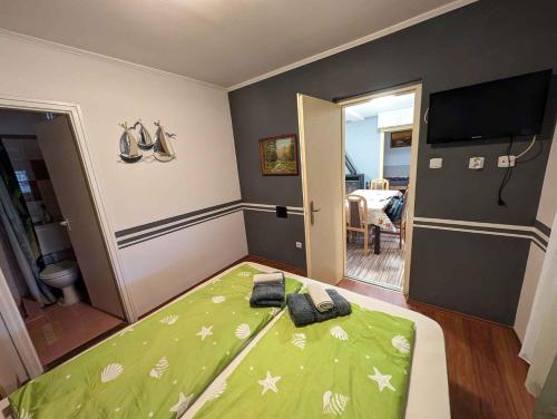 a bedroom with a bed with a green comforter at Holiday home in Sagvar - Südtransdanubien 53171 in Ságvár