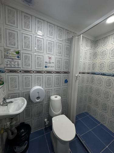 a bathroom with a toilet and a sink at Casa Hotel Manco Mora in Medellín
