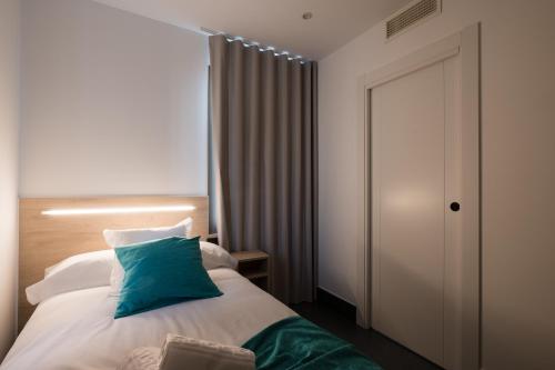 a bedroom with a bed with a green pillow on it at Hostal Dreamland in Gómezserracín